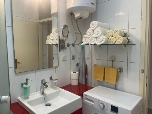 a bathroom with a sink and a washing machine at Apartman Doris in Split