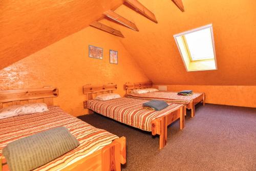 a room with three beds and a window at Duriu sodyba in Molėtai