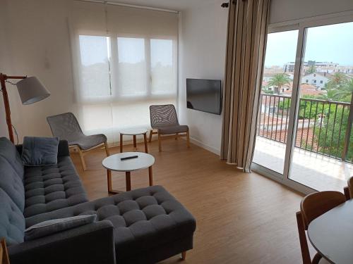 ein Wohnzimmer mit einem Sofa, Stühlen und einem TV in der Unterkunft Cambrils Pi Rodó in Cambrils