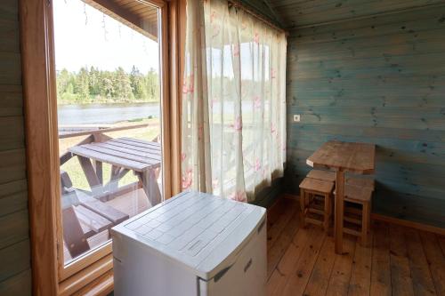 Zutēni的住宿－Juku Dzirnavas，小屋内带桌子和窗户的房间