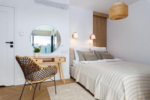 a bedroom with a bed and a chair and a mirror at Sielsko Tu - Warmiński Port #13 in Olsztyn