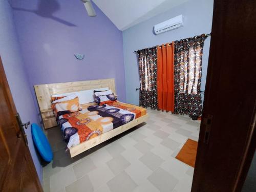 ein Schlafzimmer mit einem Bett und Vorhängen in einem Zimmer in der Unterkunft illémi Guest house in Abomey-Calavi