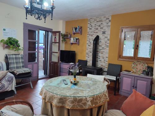 ein Wohnzimmer mit einem Tisch und einem TV in der Unterkunft Casa Alpujarreña Fina Número 27 in Bubión