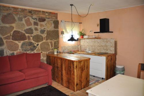 a living room with a red couch and a kitchen at Apartment Battin 44 Uckermark in Brüssow