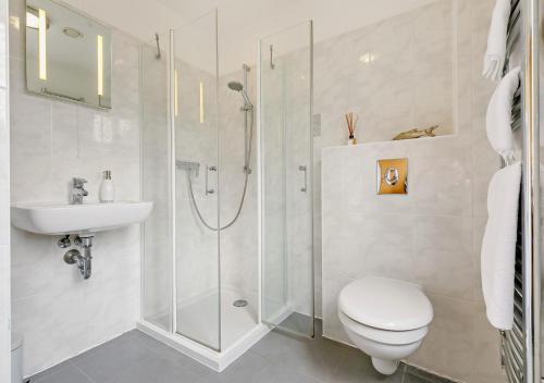y baño con ducha, aseo y lavamanos. en Saffron Cottage, en Saint Ervan