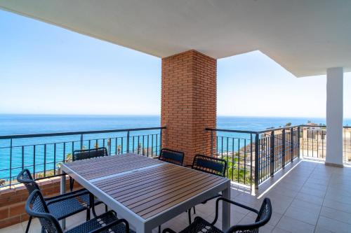 a table and chairs on a balcony with the ocean at Calaceite 3121 Ocean Paradise Casasol in Torrox Costa