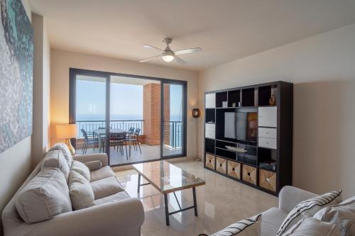 uma sala de estar com um sofá, uma televisão e uma mesa em Calaceite 3121 Ocean Paradise Casasol em Torrox Costa