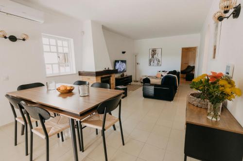 uma sala de jantar e sala de estar com mesa e cadeiras em PORCHES BOUTIQUE APARTEMENT em Porches