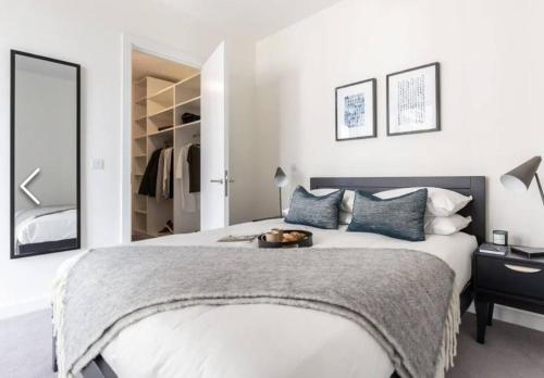 een slaapkamer met een groot wit bed met blauwe kussens bij Luxury Seaview Apartment in Dublin