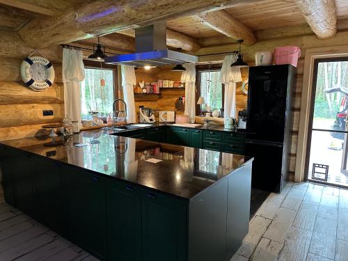 a kitchen with green cabinets and a black counter top at Wikno Villa in Nidzica