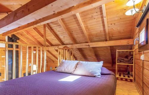 1 dormitorio con 1 cama de color púrpura en una habitación con paredes de madera en Cabana La Encina en El Gastor