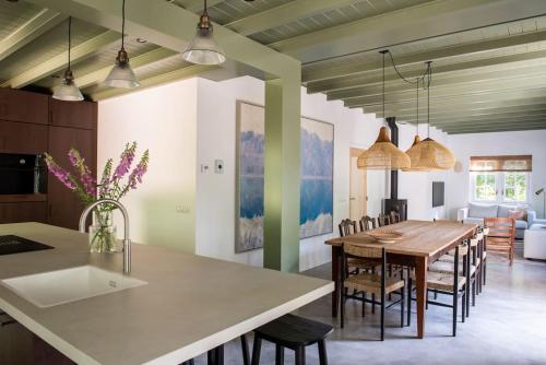 een keuken en eetkamer met een tafel en stoelen bij Fantastisch familiehuis met grote tuin I Bosrijk in Lunteren