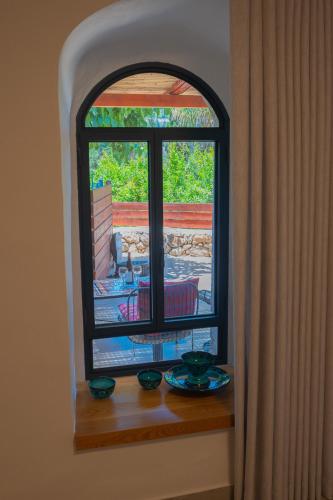 a window with a view of a patio at פרלה צימרים in ‘En Kerem