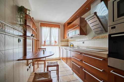 una cocina con armarios de madera y una mesa pequeña en CAMINODEHEROS, en Avilés