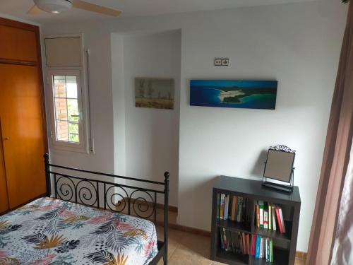 1 dormitorio con 1 cama y estantería con libros en Villa Brisas - Preciosa villa con gran intimidad y piscina, en Segur de Calafell