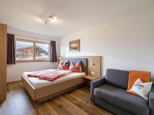 1 dormitorio con 1 cama y 1 sofá en Ferienwohnung Kircher, en Kaltenbach