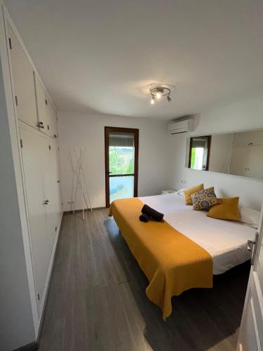 a bedroom with a large bed with a yellow blanket at Can Sastre in El Port