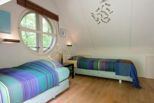 a bedroom with two beds and a window at Het Boshuis in Dalfsen