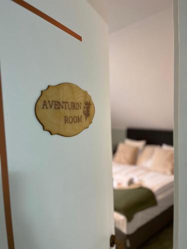 a bedroom with a bed and a sign on a door at Aventurin House *** in Révfülöp