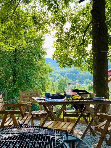 a picnic table and chairs with a view of a tree at Apartamenty Larice - balia lub sauna sesja gratis ten weekend, morsowanie w basenie in Świeradów-Zdrój