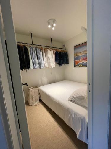 a small bedroom with a bed and some clothes at Studio Suite Lido in Koksijde
