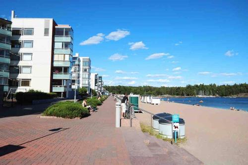 een stoep naast een strand naast een gebouw bij Meren läheisyydessä iso yksiö in Helsinki