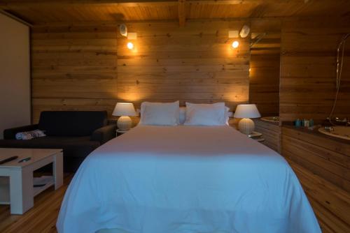 a bedroom with a large white bed and a couch at Cabanas de Apriscos in A Coruña