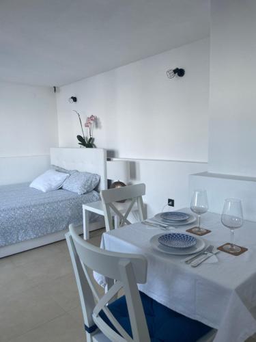 ein weißes Zimmer mit einem Tisch, Stühlen und einem Bett in der Unterkunft Studio Apartman Lana 3 in Ičići