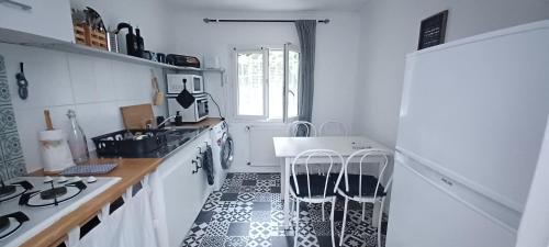 a white kitchen with a sink and a stove at la Sapinière in Saint-Vincent-de-Paul