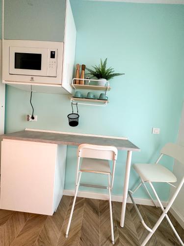 a small kitchen with a counter and a table and two chairs at Studio 21 in Bucharest