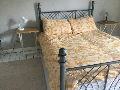 a bedroom with a bed with a yellow and white comforter at 3 Bed Home on Edge of Lake District in Winder