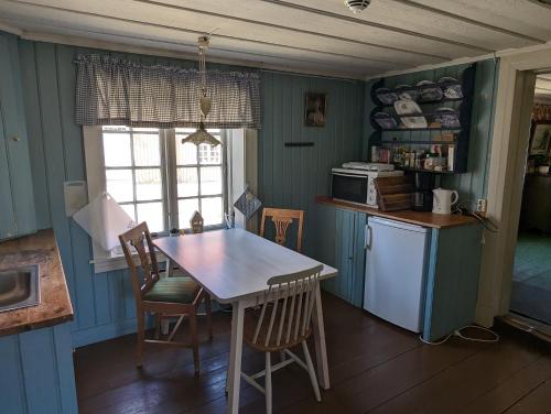 uma cozinha com paredes azuis e uma mesa e cadeiras em Magasinet em Fredrikstad