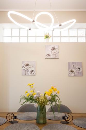 a vase of flowers on a table with a chandelier at Luxury & Cozy apartment in Messini