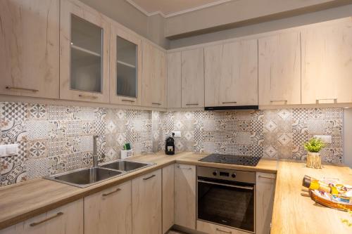a kitchen with wooden cabinets and a sink at Luxury & Cozy apartment in Messini