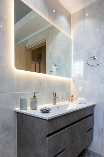 a bathroom with a sink and a mirror at Luxury & Cozy apartment in Messini