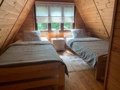 two twin beds in a room with a window at Domek Nadmorski KASZUBA in Władysławowo