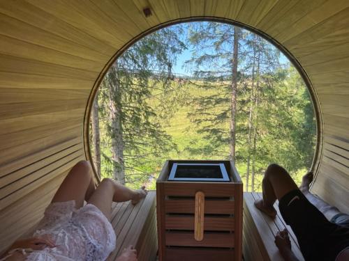 two women sitting in a round window in a sauna at Les Écrins du Val de Mouthe, JURA in Petite Chaux