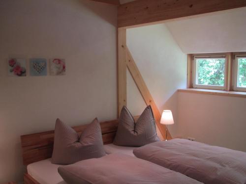 a bedroom with a bed with pillows and a window at Exklusives Holzhaus in Burg