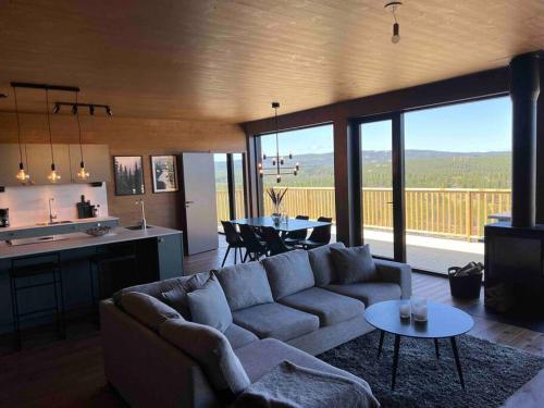 a living room with a couch and a kitchen and a table at Idre Northpark in Idre