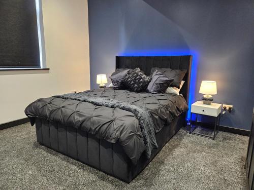 a bedroom with a large bed with a blue light at Sun Inn - Boutique Apartments Bingley in Bradford