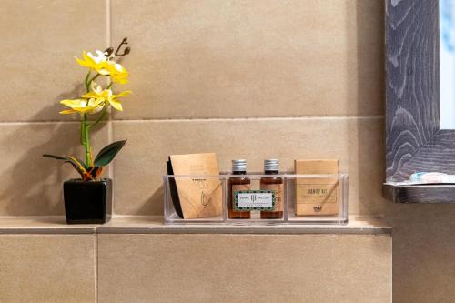 a shelf with three bottles of honey and a vase with flowers at Demiani House in Sibiu