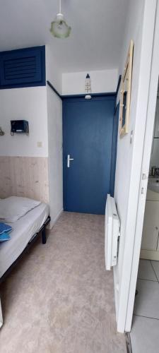 a hospital room with a blue door and a bed at Détente à la mer in La Guérinière