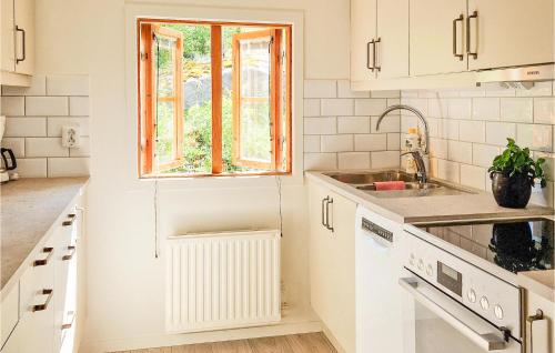 cocina blanca con fregadero y ventana en 3 Bedroom Amazing Home In Vrigstad en Vrigstad