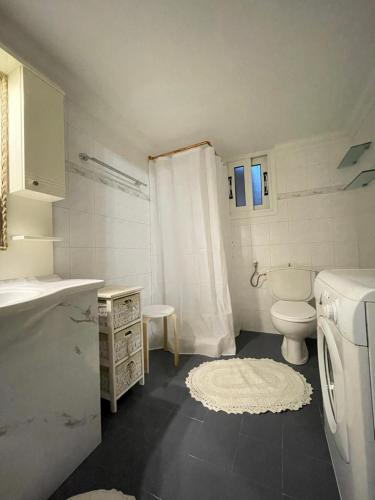 uma casa de banho com um WC e uma máquina de lavar roupa em Country House em Karlovasi