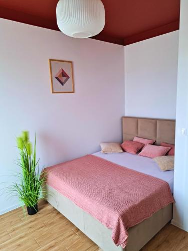 a bedroom with a large bed with pink pillows at Apartament Rubin in Zator