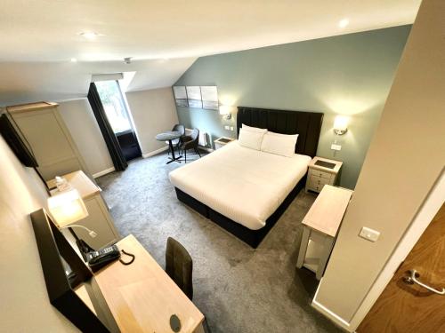 a hotel room with a bed and a desk at South Lawn Hotel in Lymington