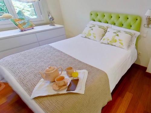 a bedroom with a bed with a tray of teaiments on it at Chalet Playa América. in Nigrán