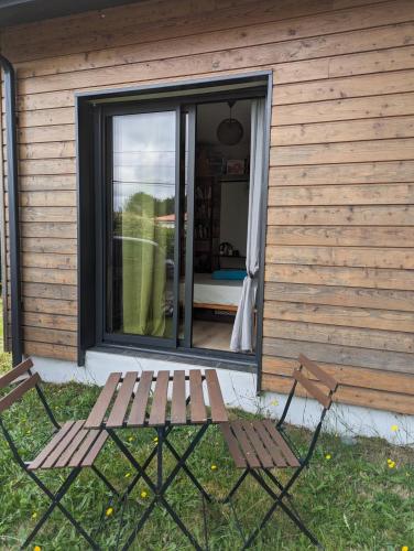 un banc en bois assis devant une maison dans l'établissement Chambre privée chez l'habitant, à Parentis-en-Born