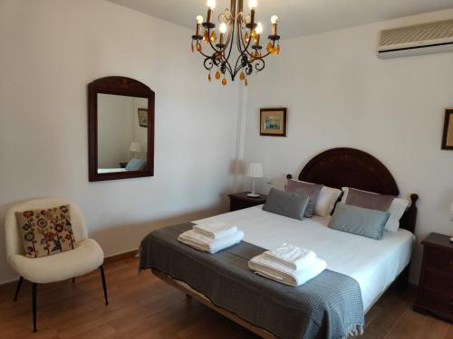 een slaapkamer met een bed met een spiegel en een stoel bij Apartamento El Rinconcito de Martina in Jarandilla de la Vera