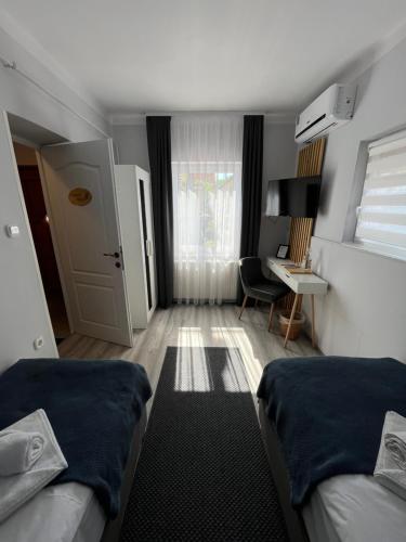 a small room with two beds and a desk at Aventurin House *** in Révfülöp